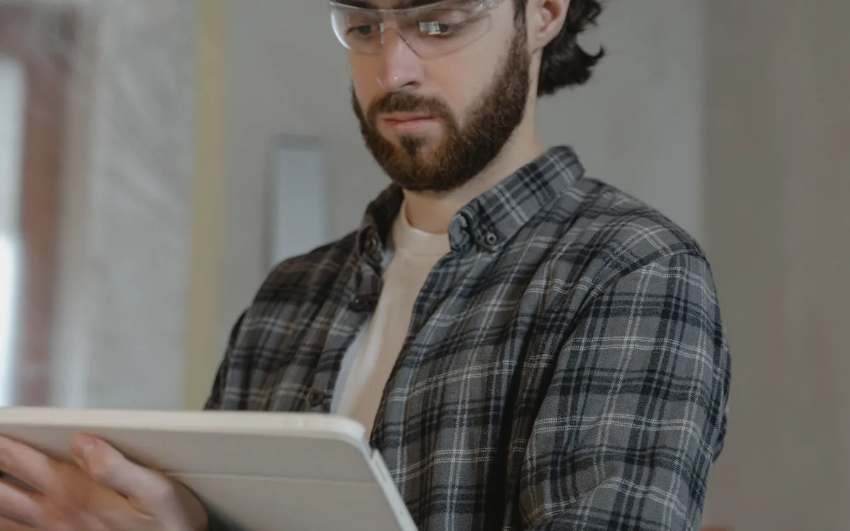 Jefe de obra revisando información en una tablet dentro de una construcción en proceso