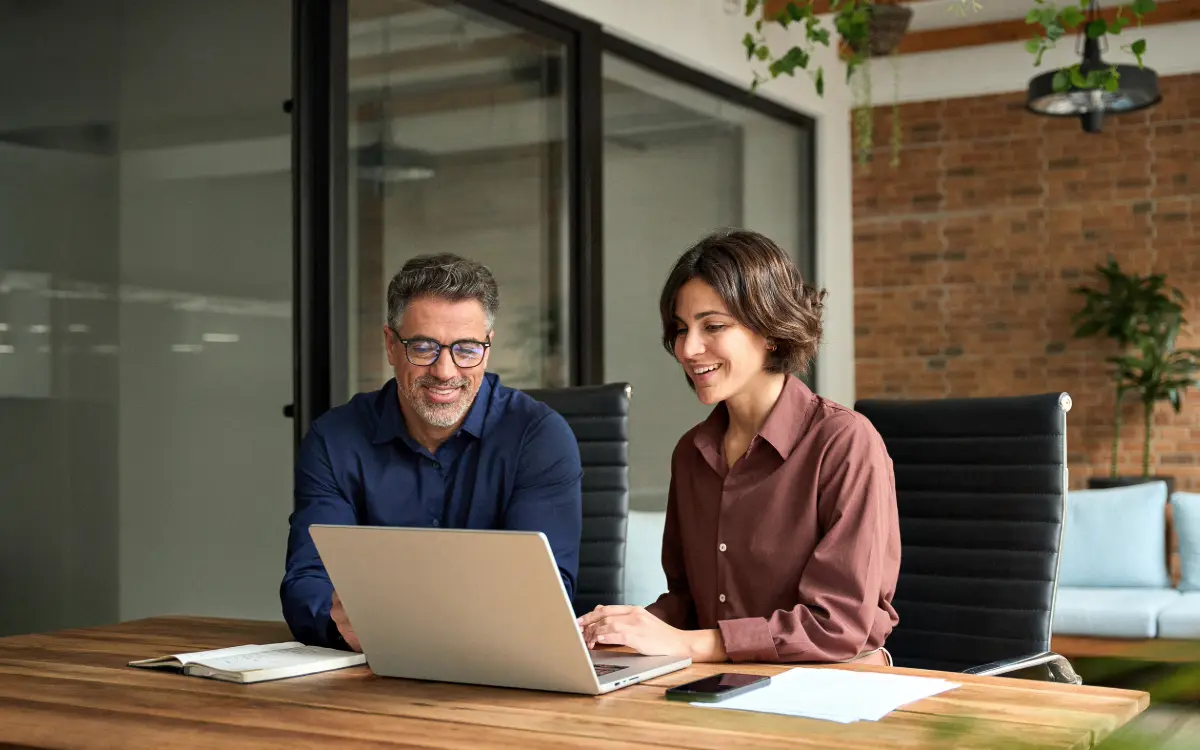 Architect and site manager reviewing the final construction certificate alongside a progress certification in the technical office