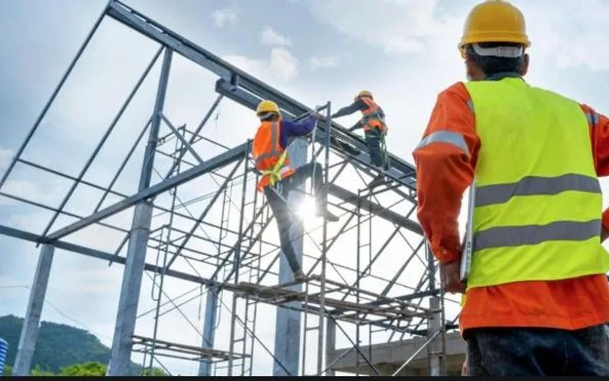 Trabajadores levantando la estructura metálica de una nave industrial en construcción