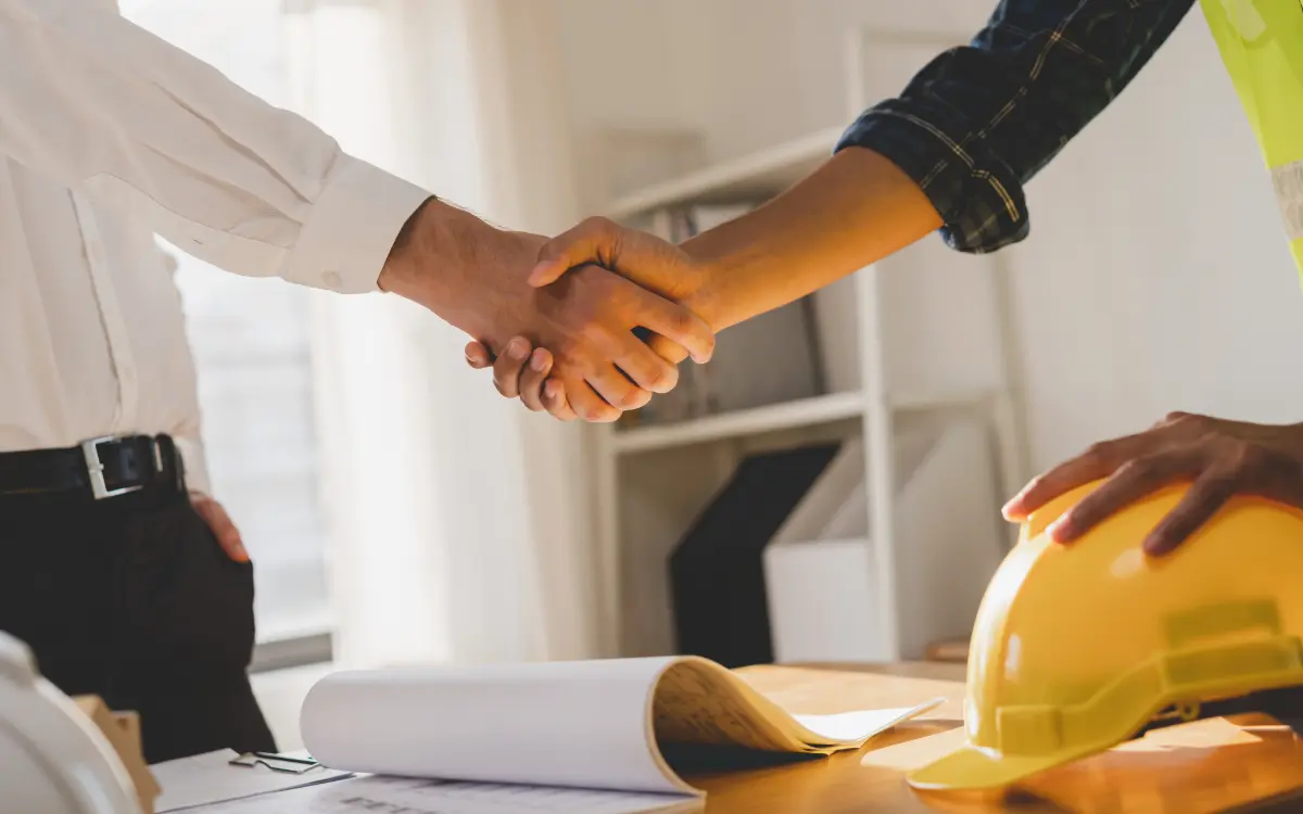 Jefe de obra coordinando la gestión de personal en construcción con su equipo en el tajo