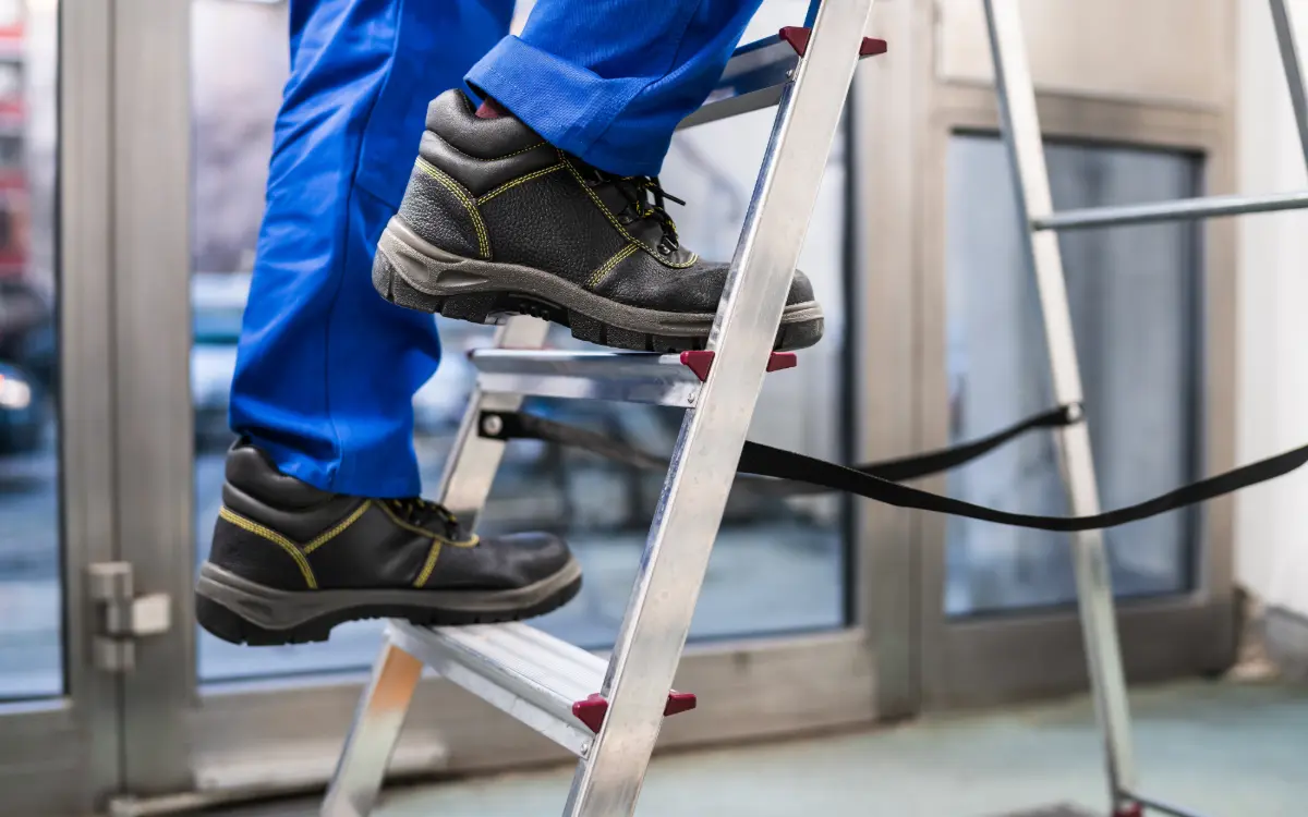 Construction operative working at height fitted with a safety harness and clipped onto a lifeline